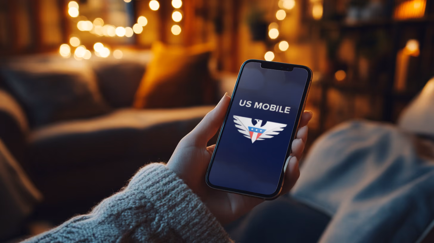 A person holding iphone with US Mobile logo on the screen