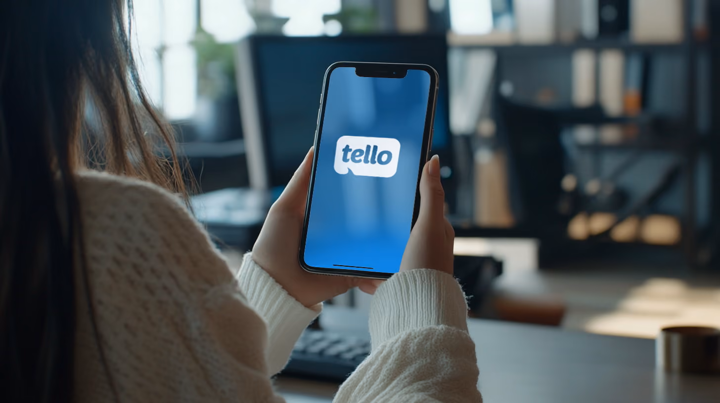 Young woman holding phone with Tello Mobile logo on the screen