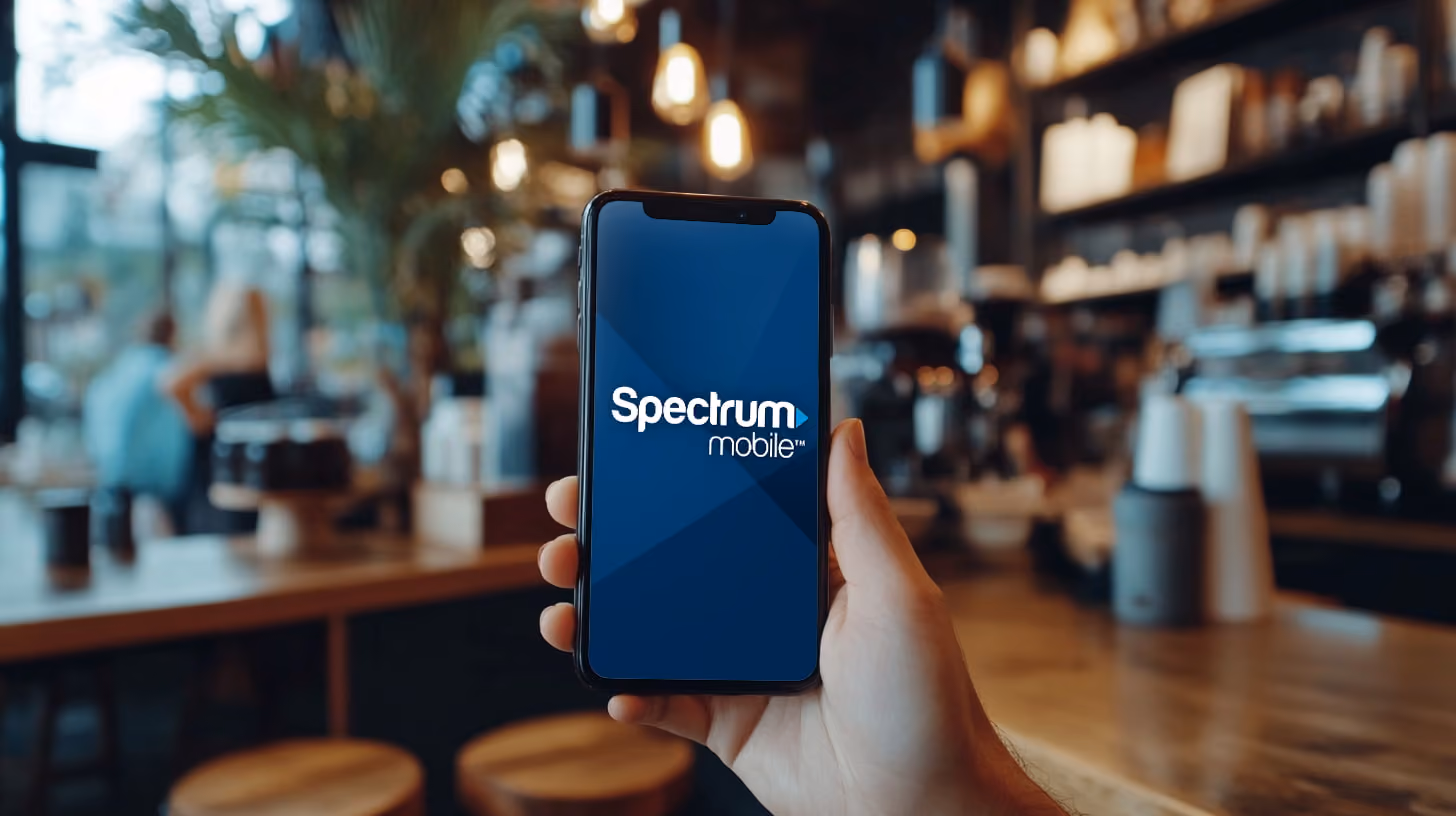 A person holding A smartphone with Spectrum Mobile logo onthe screen