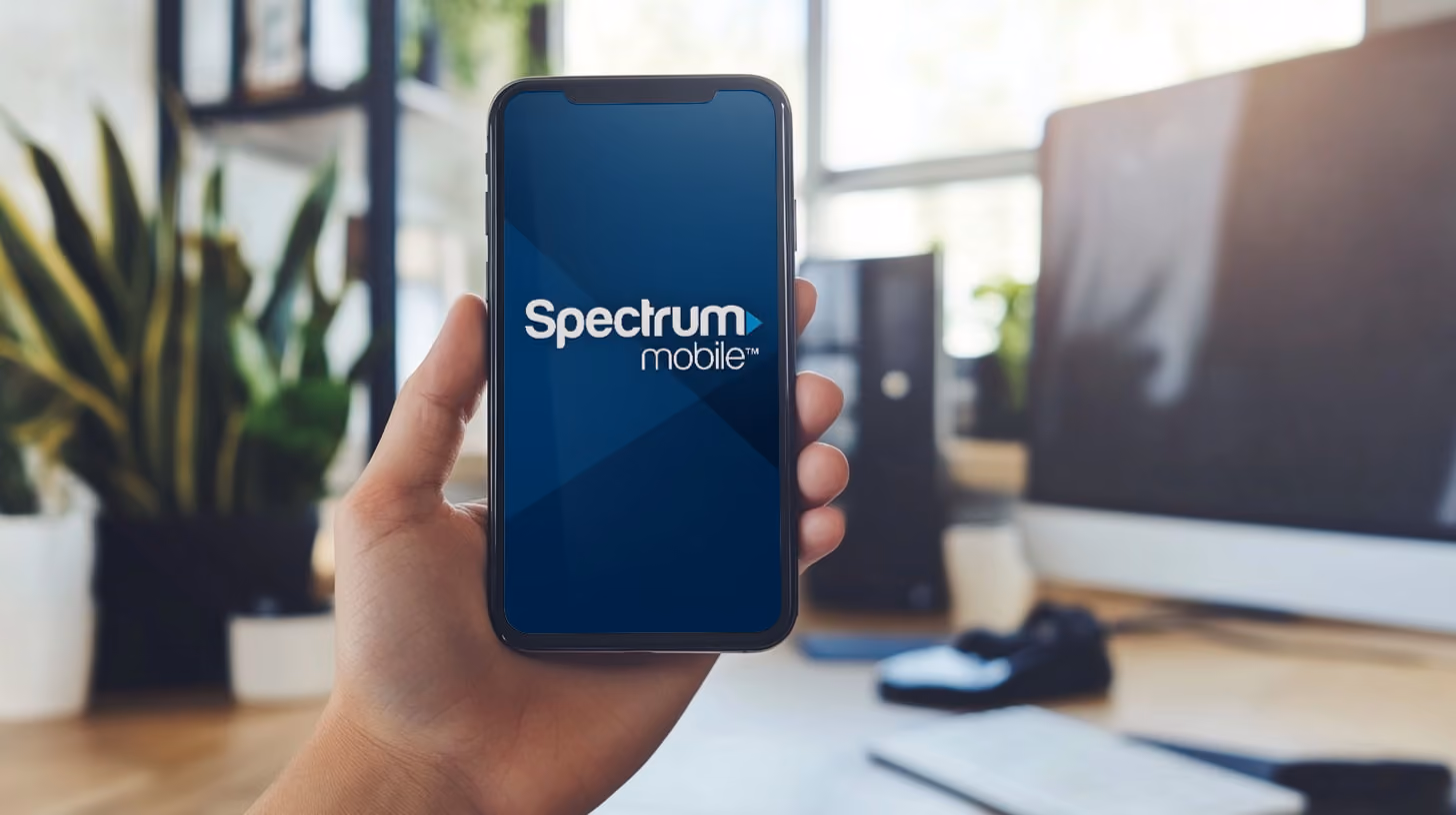 Hand Holding Smartphone with Spectrum Mobile logo on the screen