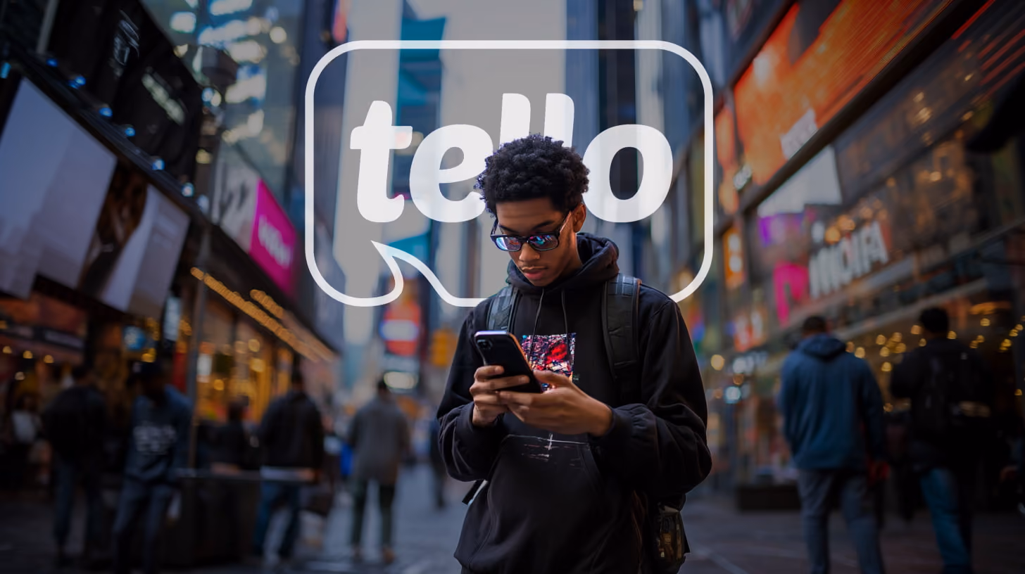A young man focuses on his phone, appearing engaged with the content displayed, in the midtown