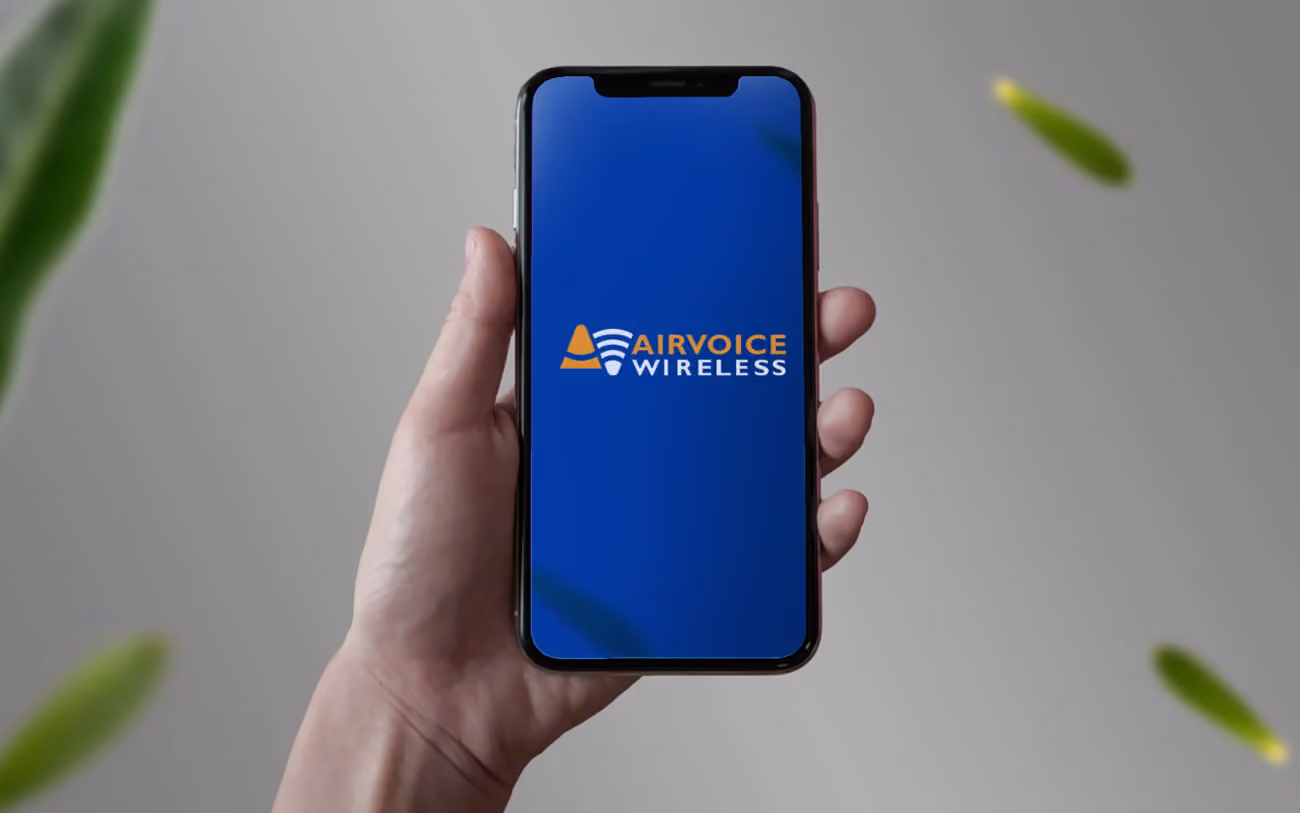 Hand holding phone with Airvoice Wireless logo on the screen