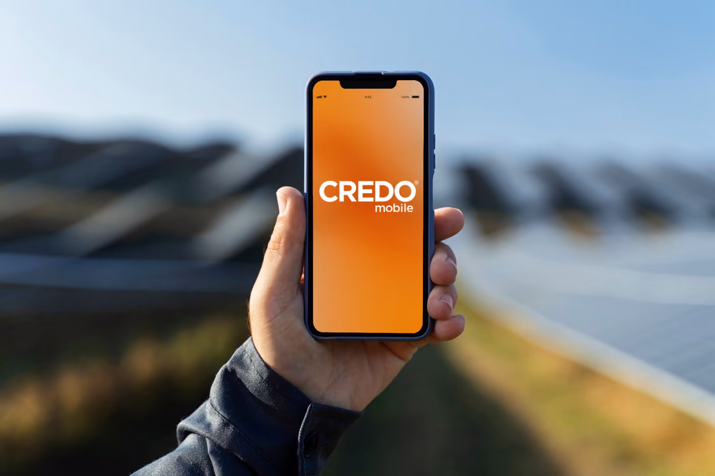Close up hand holding device with Credo Mobile logo on the screen