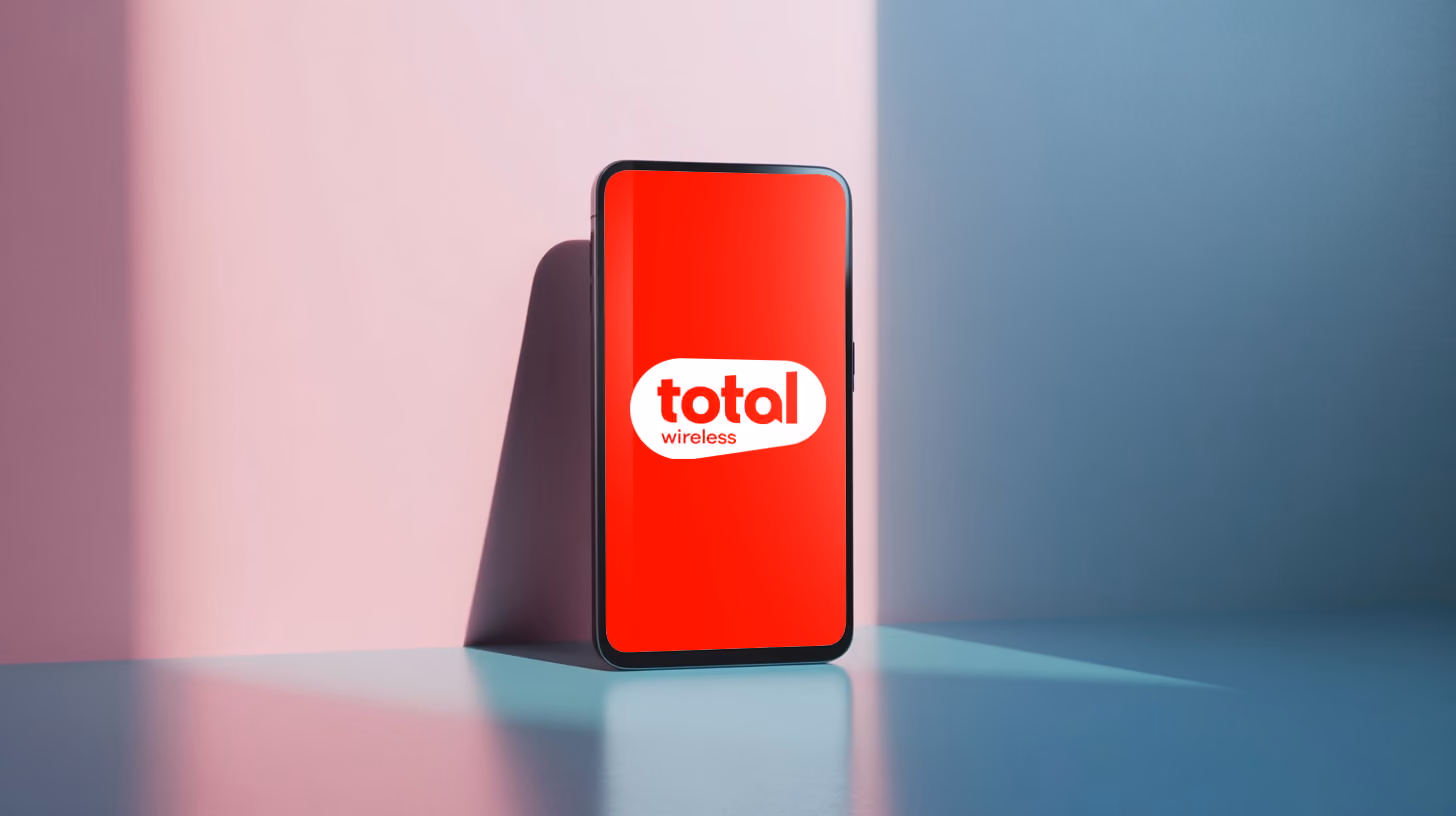 a mobile phone standing on a table, with Total Wireless logo on the screen