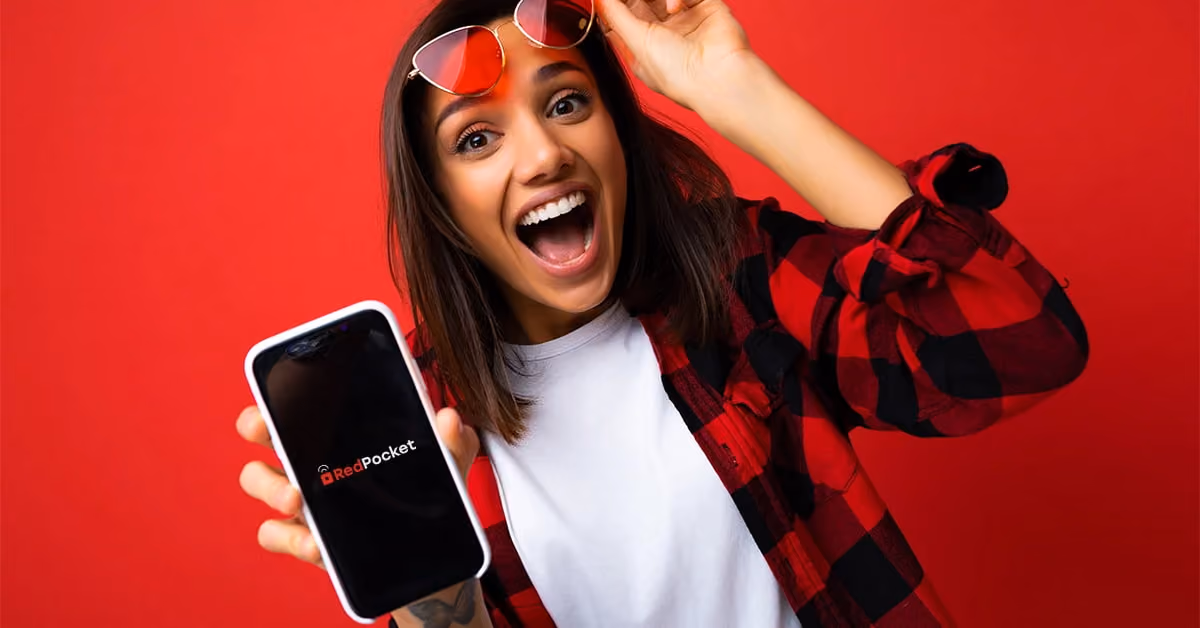 A happy woman holding phone with RedPocket logo on the screen