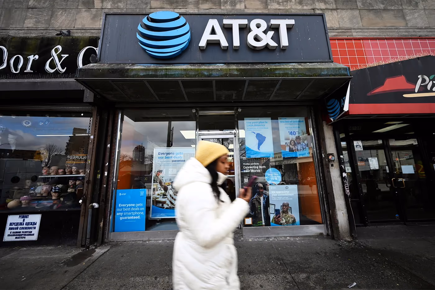 a woman walking in the fron of AT&T Store