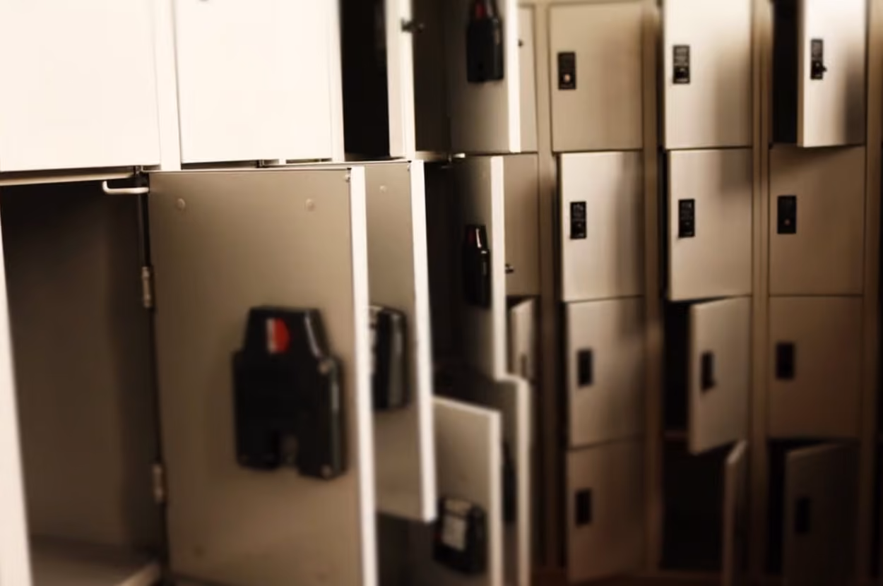 A row of lockers in a hallway, showcasing various colors and designs, organized for student use