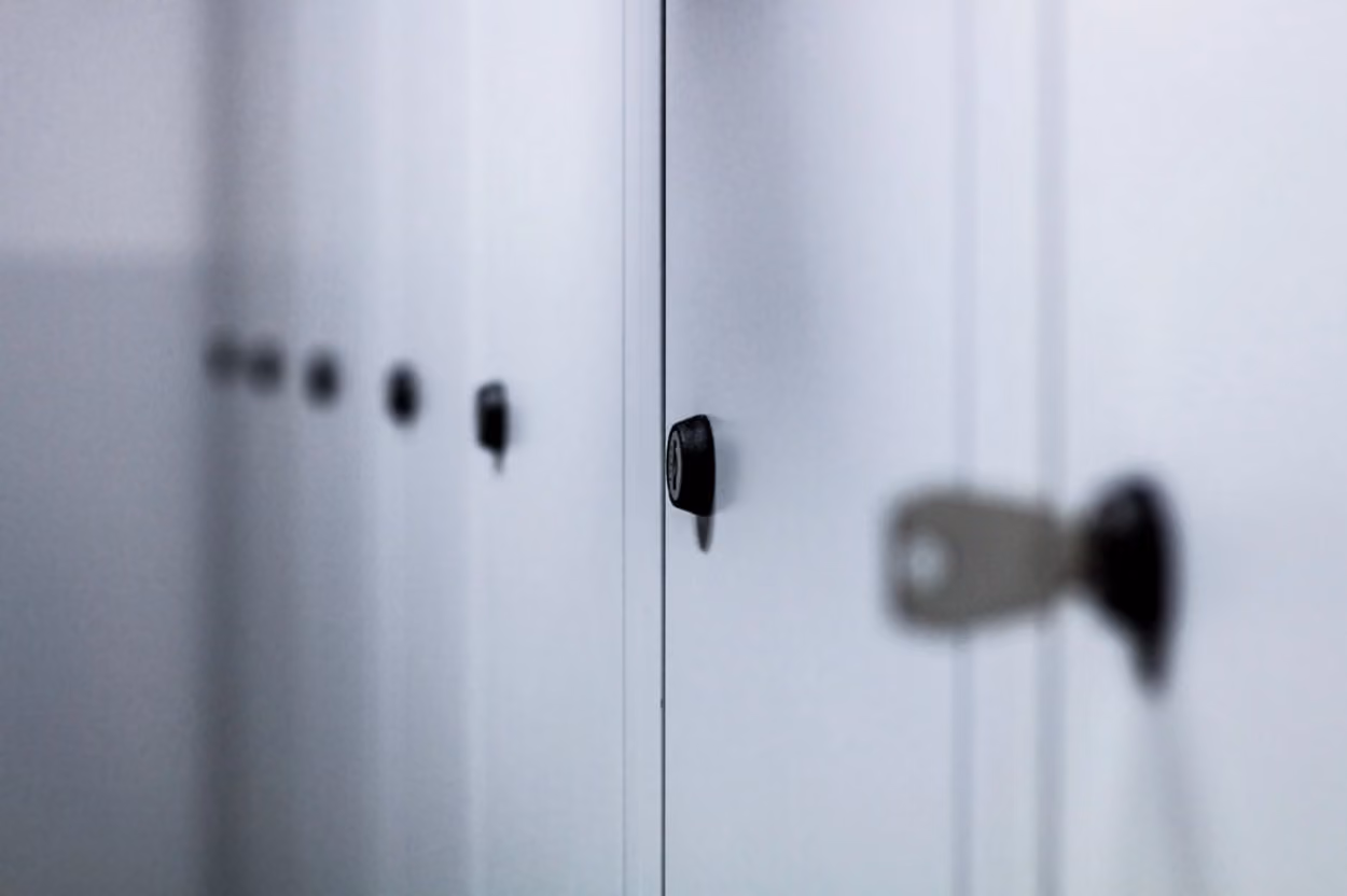 A row of lockers in a hallway, showcasing various colors and designs, organized for student use