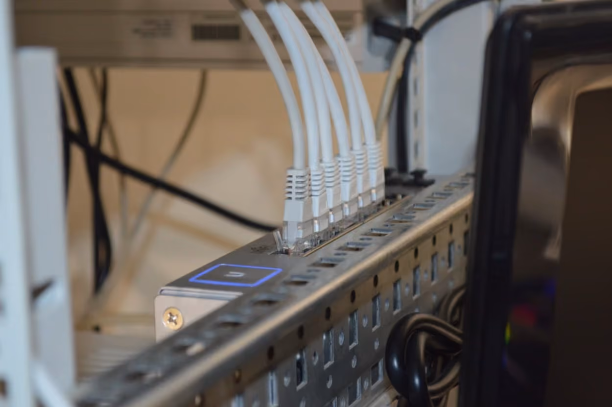 A computer surrounded by numerous wires, illustrating a complex network of connections and technology.