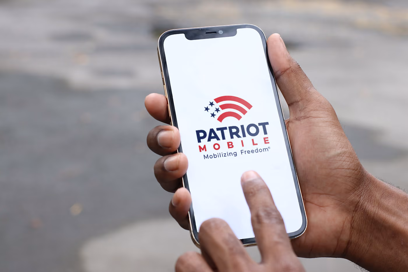 A person holding a smartphone with patriot mobile logo on the screen