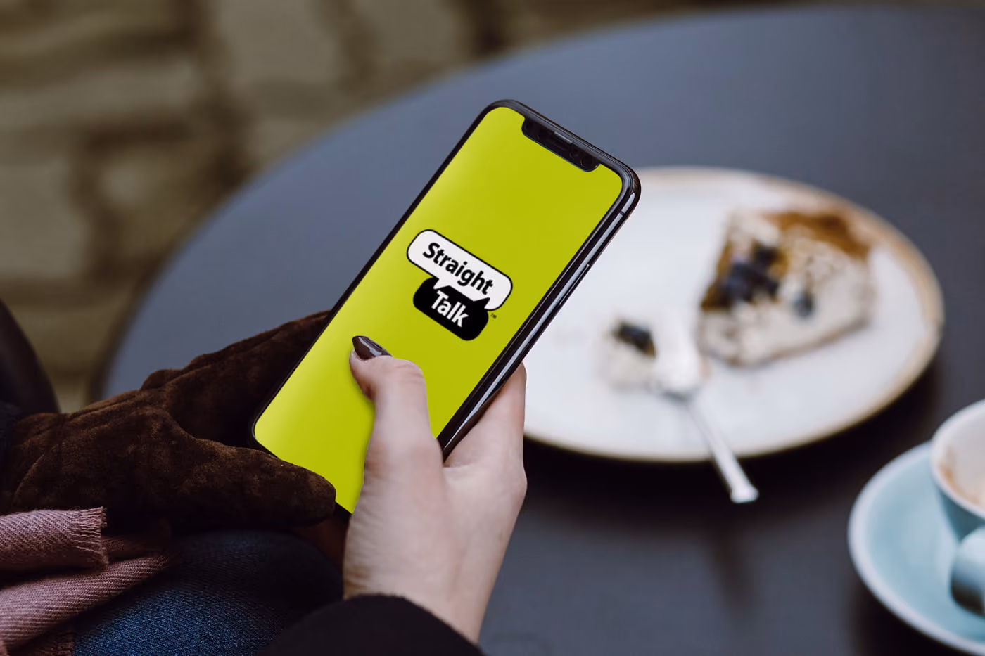A person holding iphone with straight talk logo on the screen