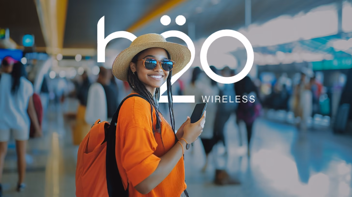 A woman standing at the terminal with h2o wireless logo on the background