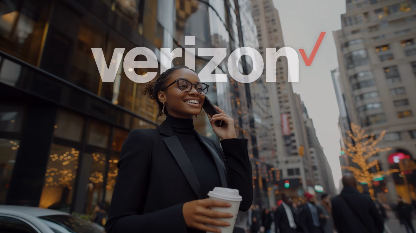 A happy young woman with glasses and black suit, calling someone with her phone, appearing engaged with the content displayed, in the midtown