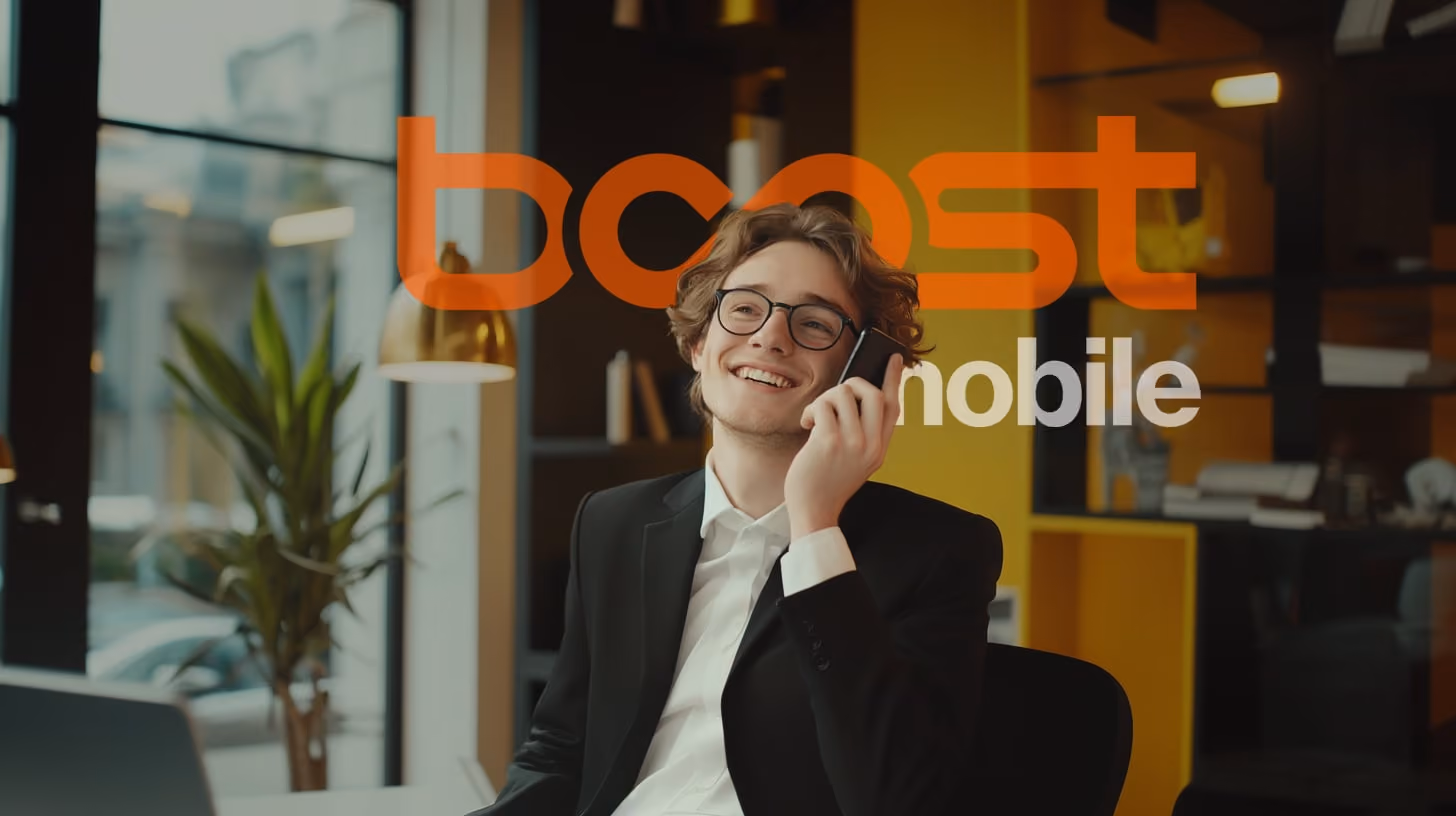 A happy young man with glasses and black suit, calling someone with her phone, appearing engaged with the content displayed, in his modern office room