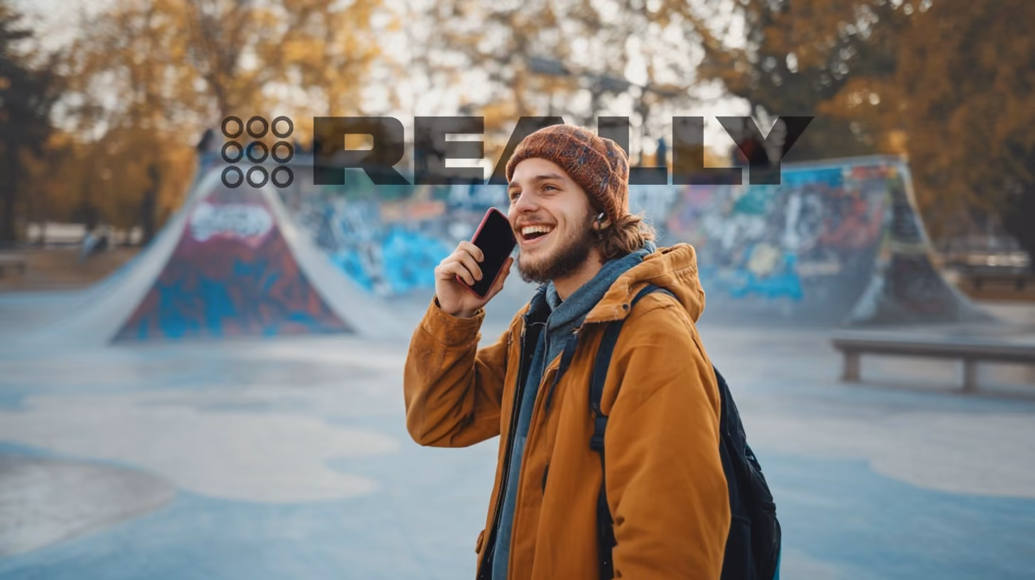 A person calling someone with his phone, at the rooftop bar, REALLY Wireless logo on the background