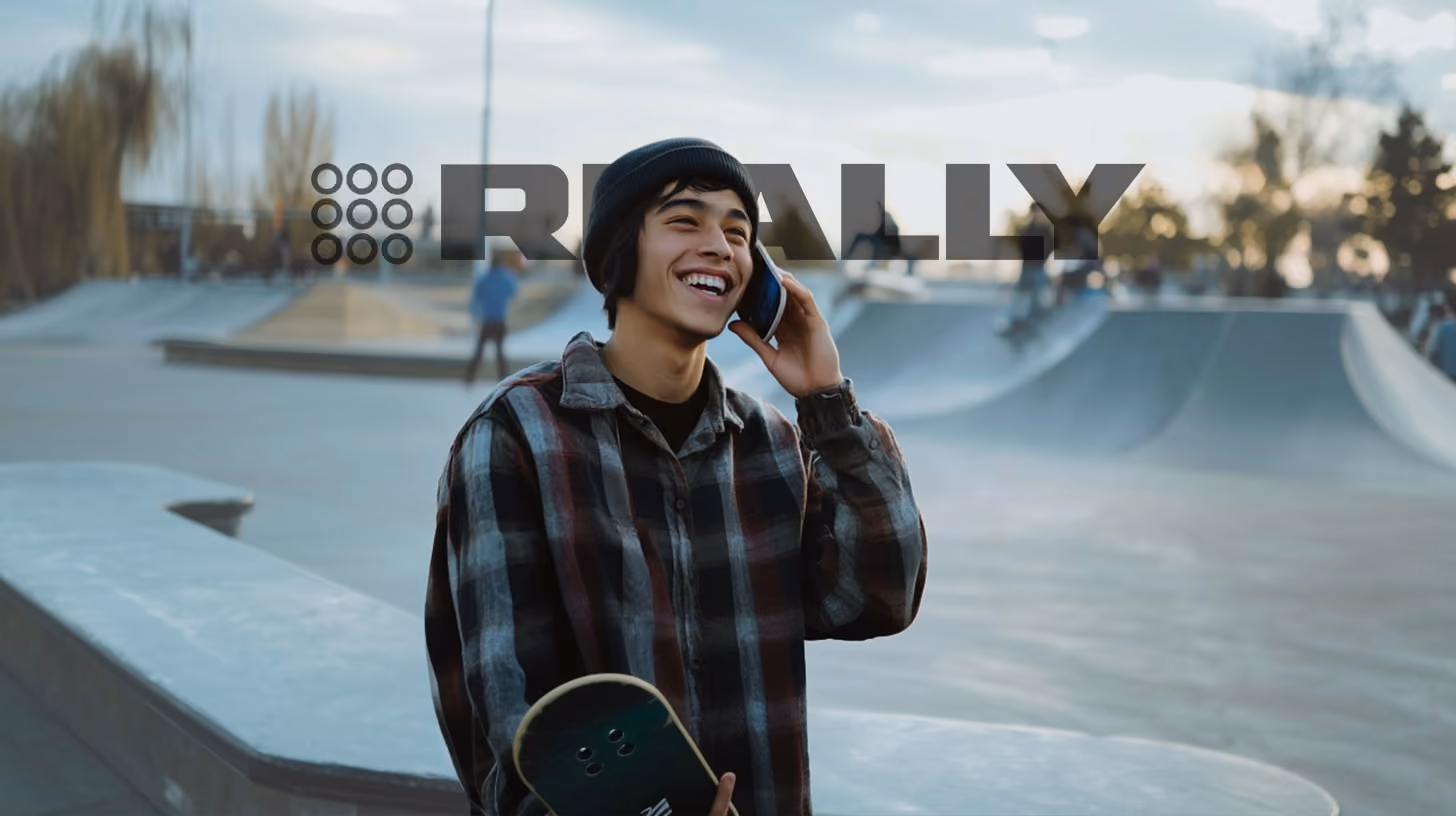 smiling man calling someone with his phone, standing at skate park, happy vibes