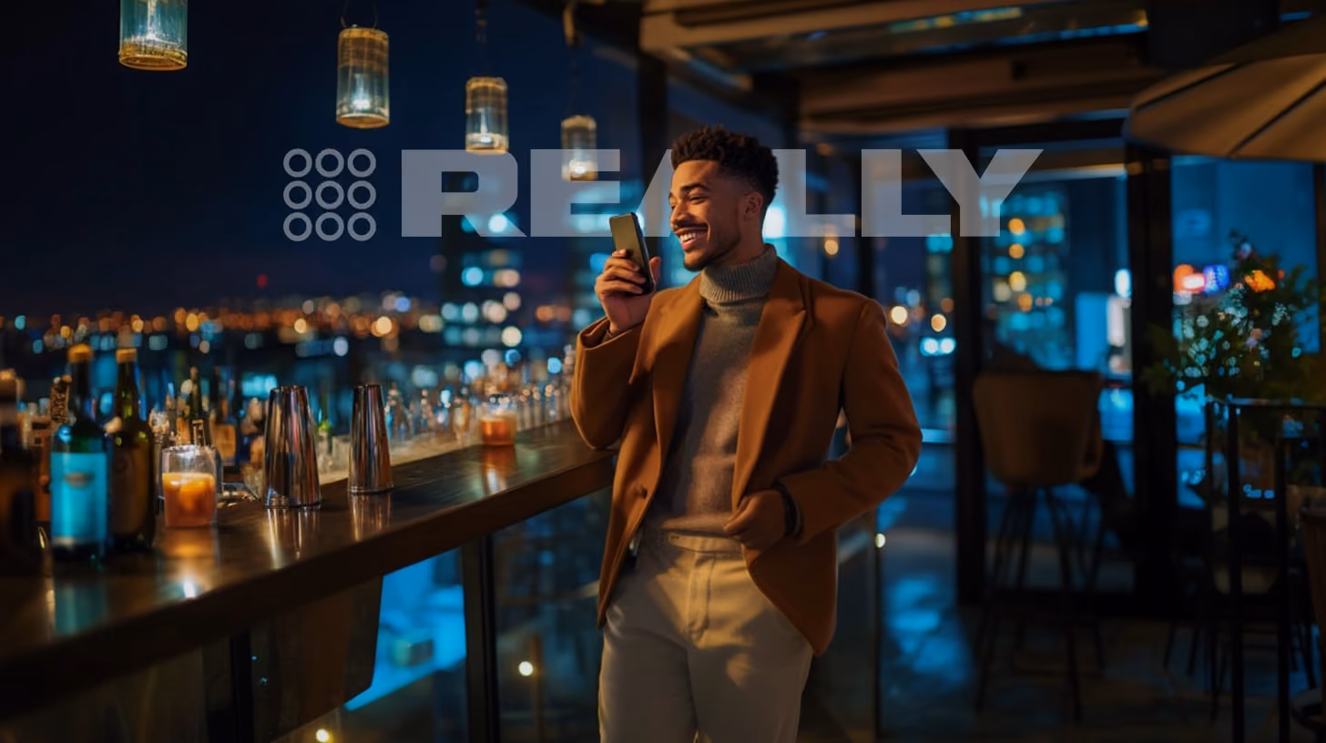 A person calling someone with his phone, at the rooftop bar, REALLY Wireless logo on the background