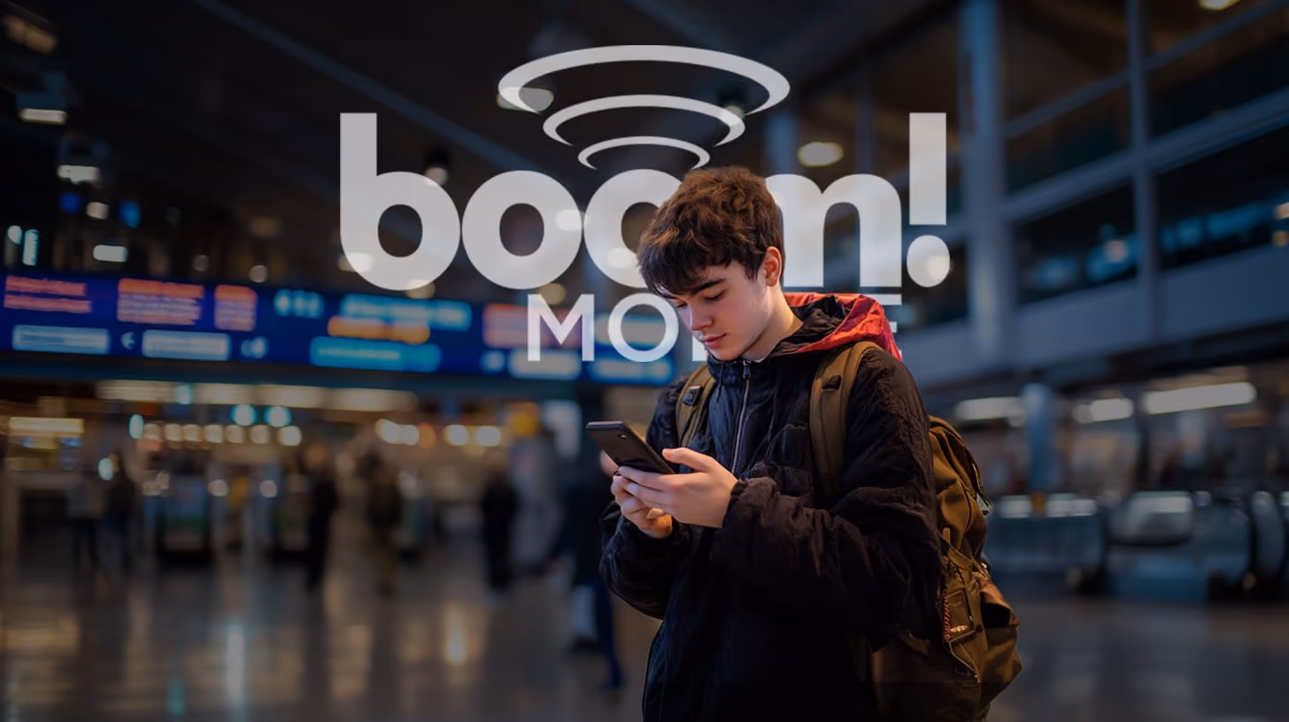 A young man holding and watching on his phone outdoors