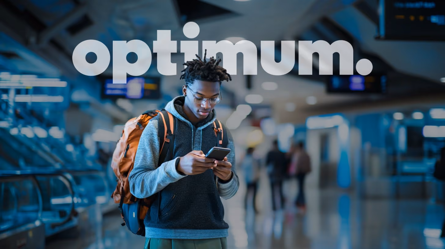 A young man focuses on his phone, appearing engaged with the content displayed, in the terminal