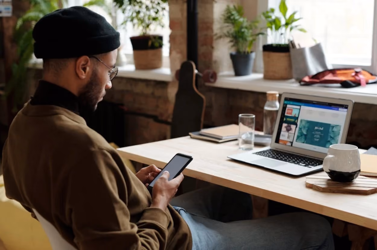 A man sitting at home, focused on his smartphone, engaged in a digital activity.
