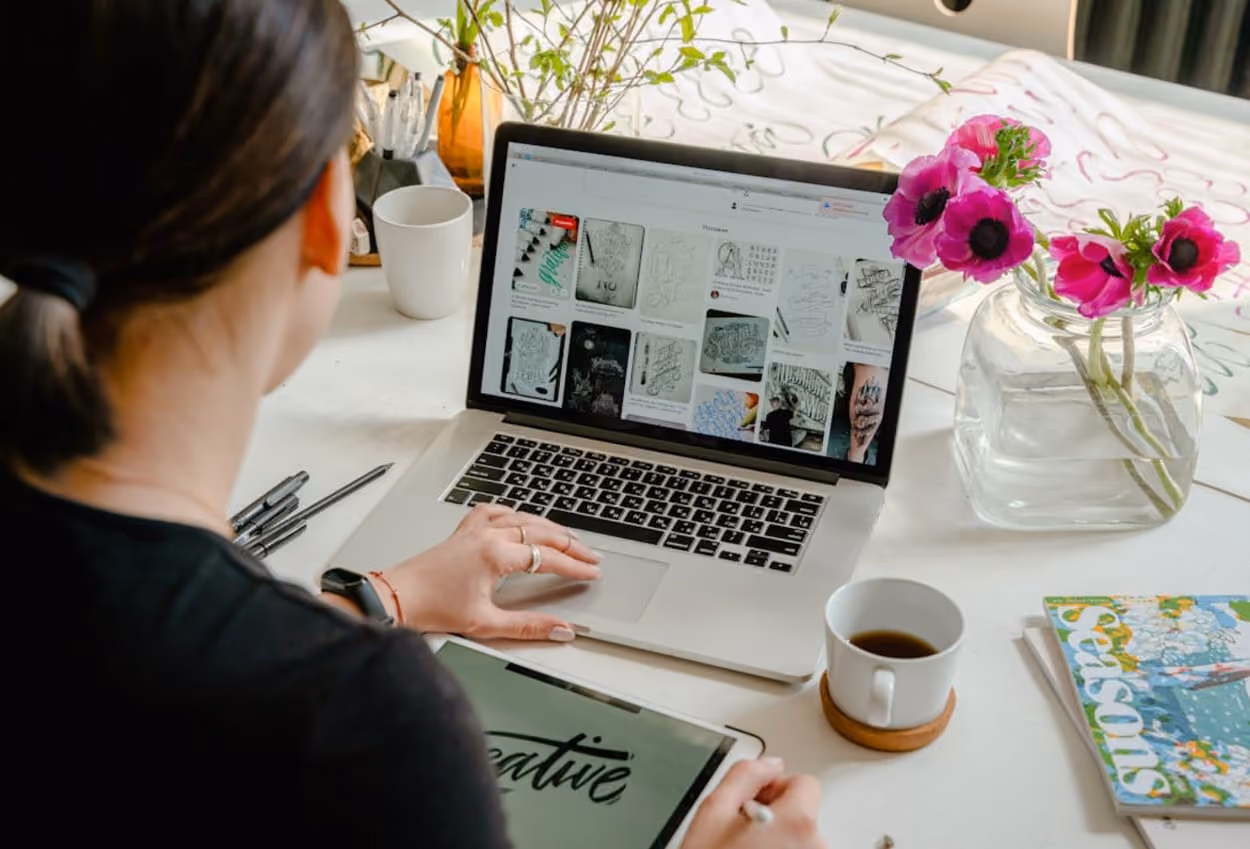 A woman focused on her laptop, seated at a desk, engaged in her work with a professional demeanor.