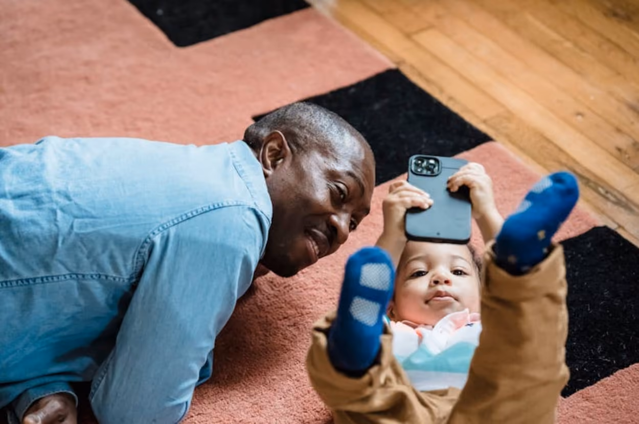 A Dad watching on his kid playing phone