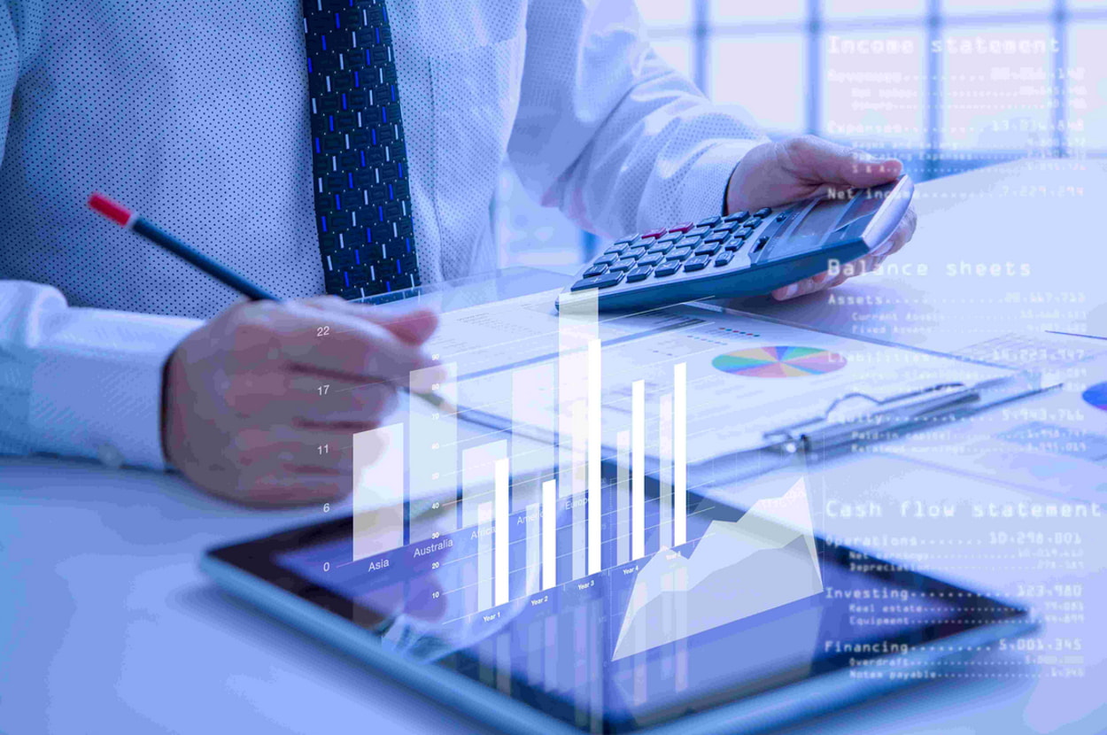 A man operates a calculator and tablet to develop a graph from his calculations.