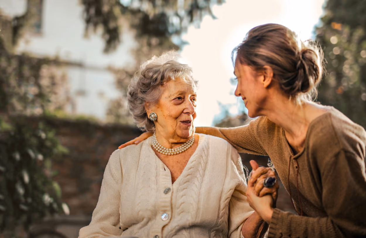A woman engages in conversation with an older woman, both appearing attentive and interested in the discussion.