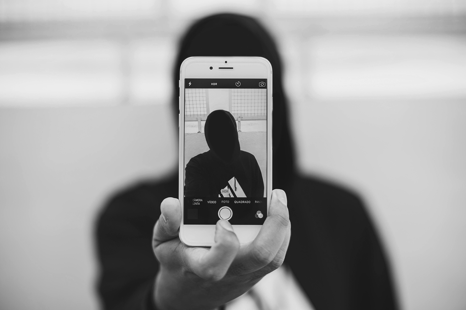 Person Taking a Photo Using Iphone in black and white photograph