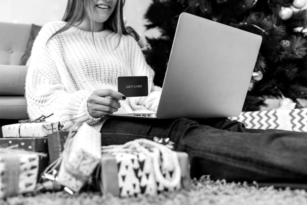 Smiling woman holding credit card and laptop 