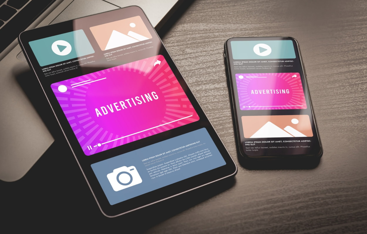 Mobile advertising concept displayed on a smartphone and tablet, showcasing digital ads and marketing strategies.