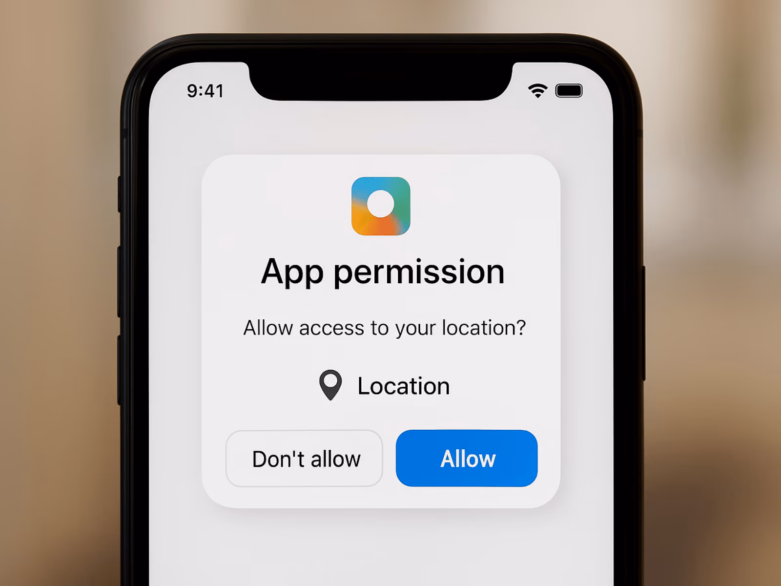Editorial image of a phone showing an app permission request to access location data, representing user consent, privacy awareness, and mobile data tracking practices.