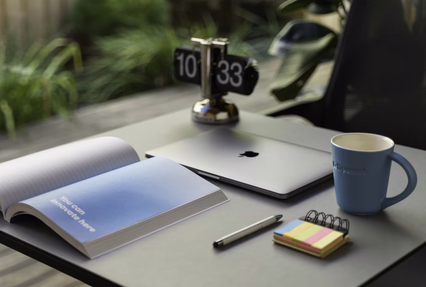 A notebook and a coffee mug placed on a wooden desk, creating a cozy workspace atmosphere.