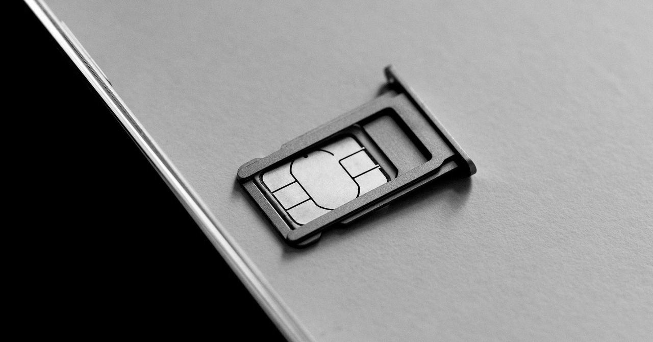 A close-up of a SIM card partially inserted into a metallic SIM tray on a smartphone. The image conveys a sense of technology and connectivity.