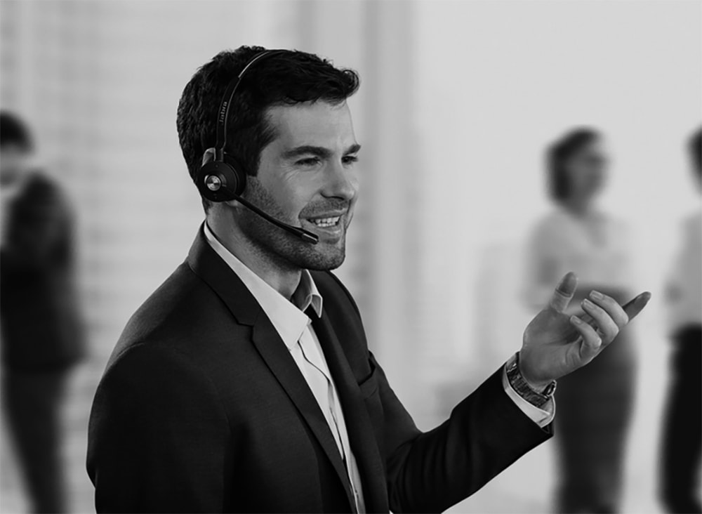 A man wearing a headset, engaged in conversation, appears focused and attentive. 