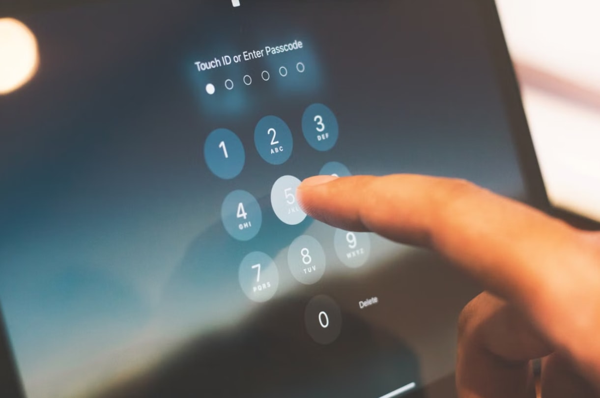A person pressing a button on a tablet, focused on the screen with a neutral expression.