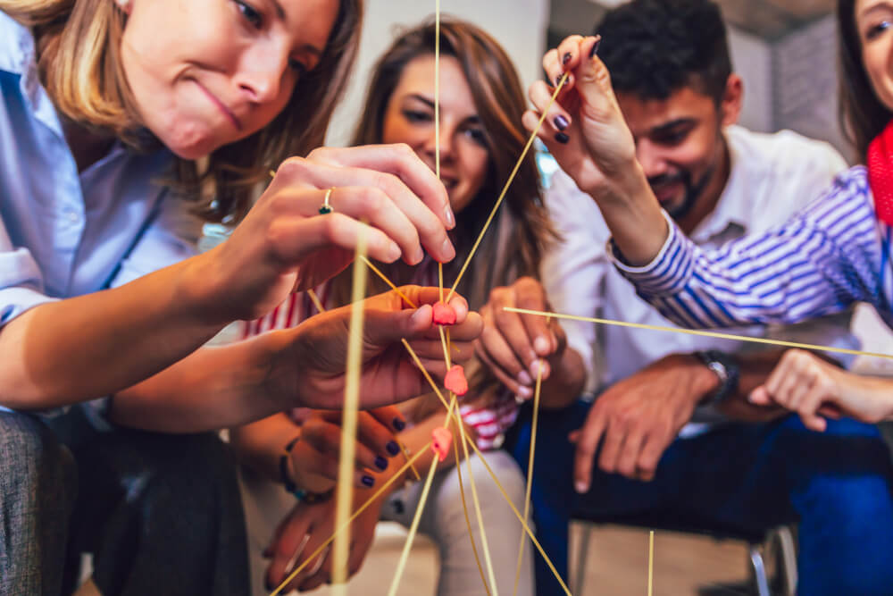 zaposleni igraju igru sklapanja oblika na team buildingu
