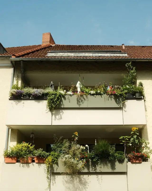 Wohnhaus mit Balkonen mit grünen Pflanzen