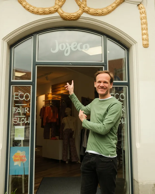 Mann steht vor Eingang von Jojeco