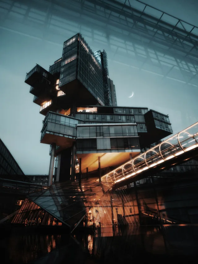 Modern architectural building with cantilevered glass cubes illuminated at dusk under a crescent moon.