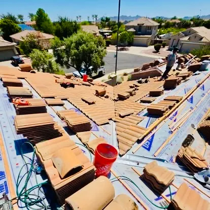 New roof underlayment being installed beneath concrete tile in Gilbert, Arizona