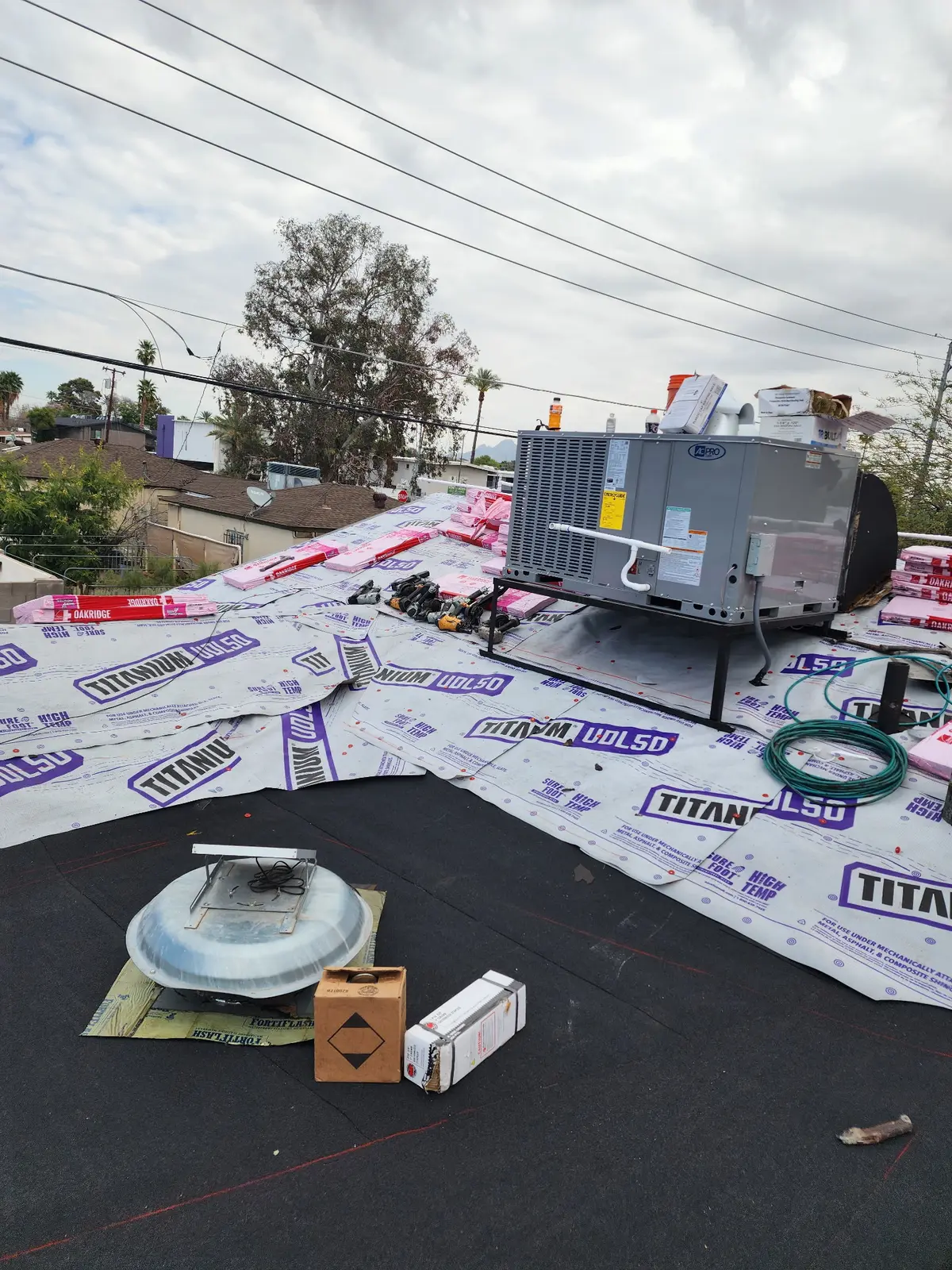 Architectural shingle installation staged over synthetic underlayment