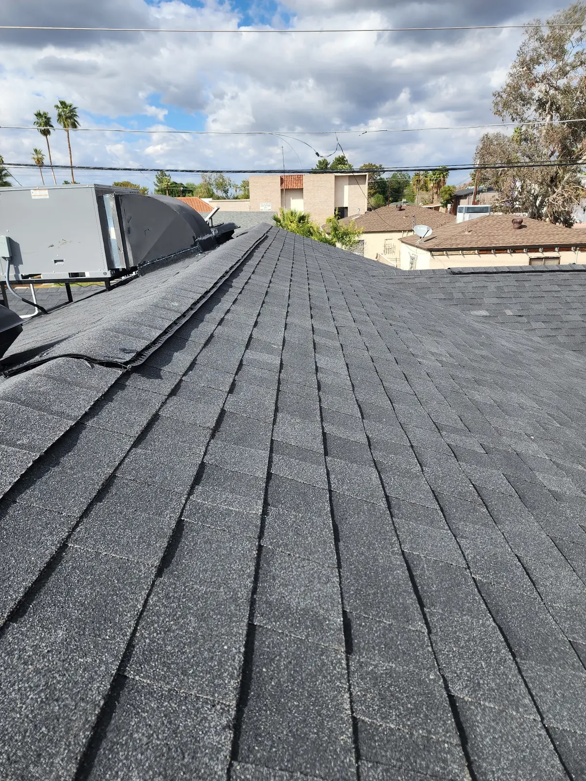 Completed dark gray architectural shingle roof slope