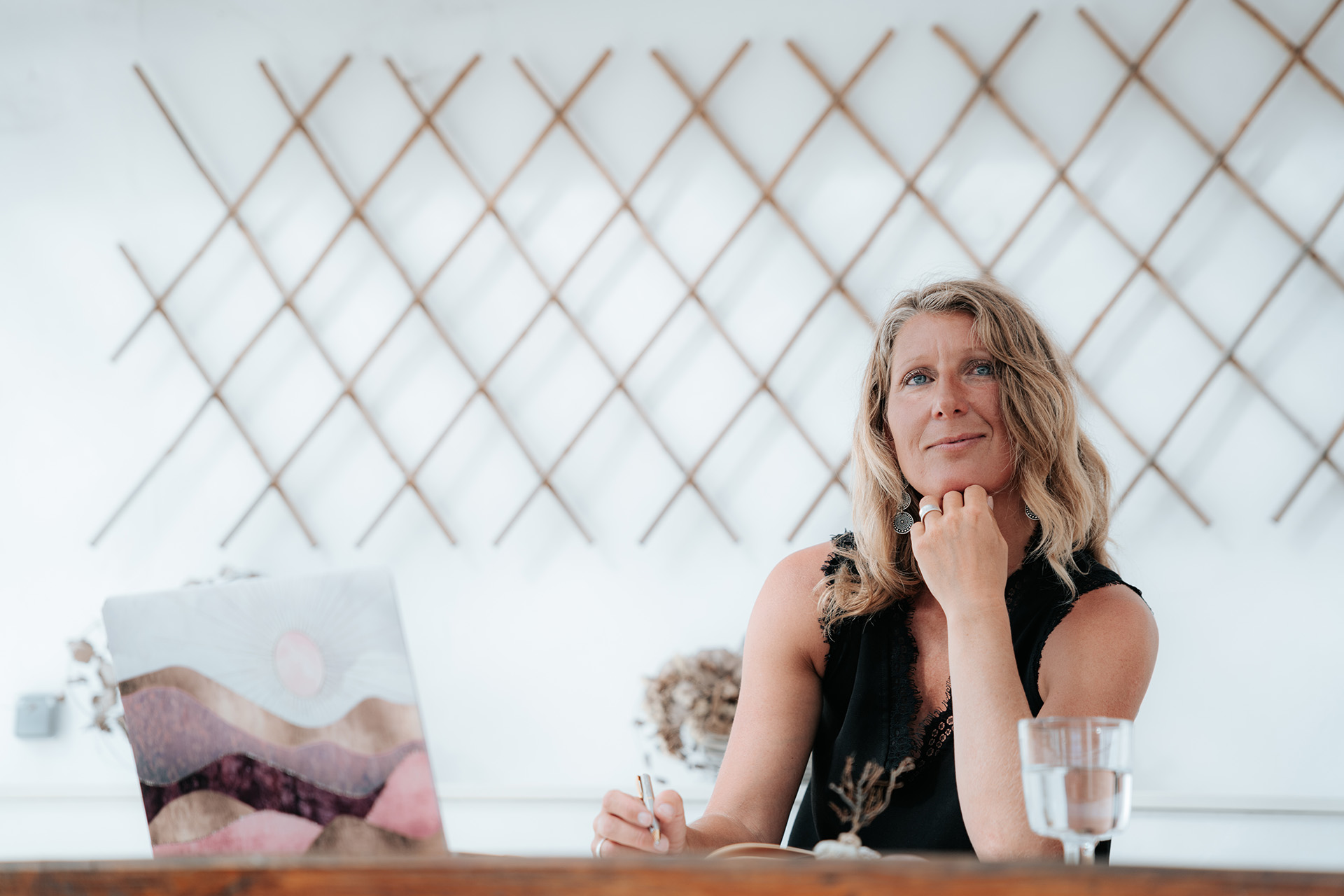 martina knall sitzt entspannt am tisch und blickt reflektiert in die kamera