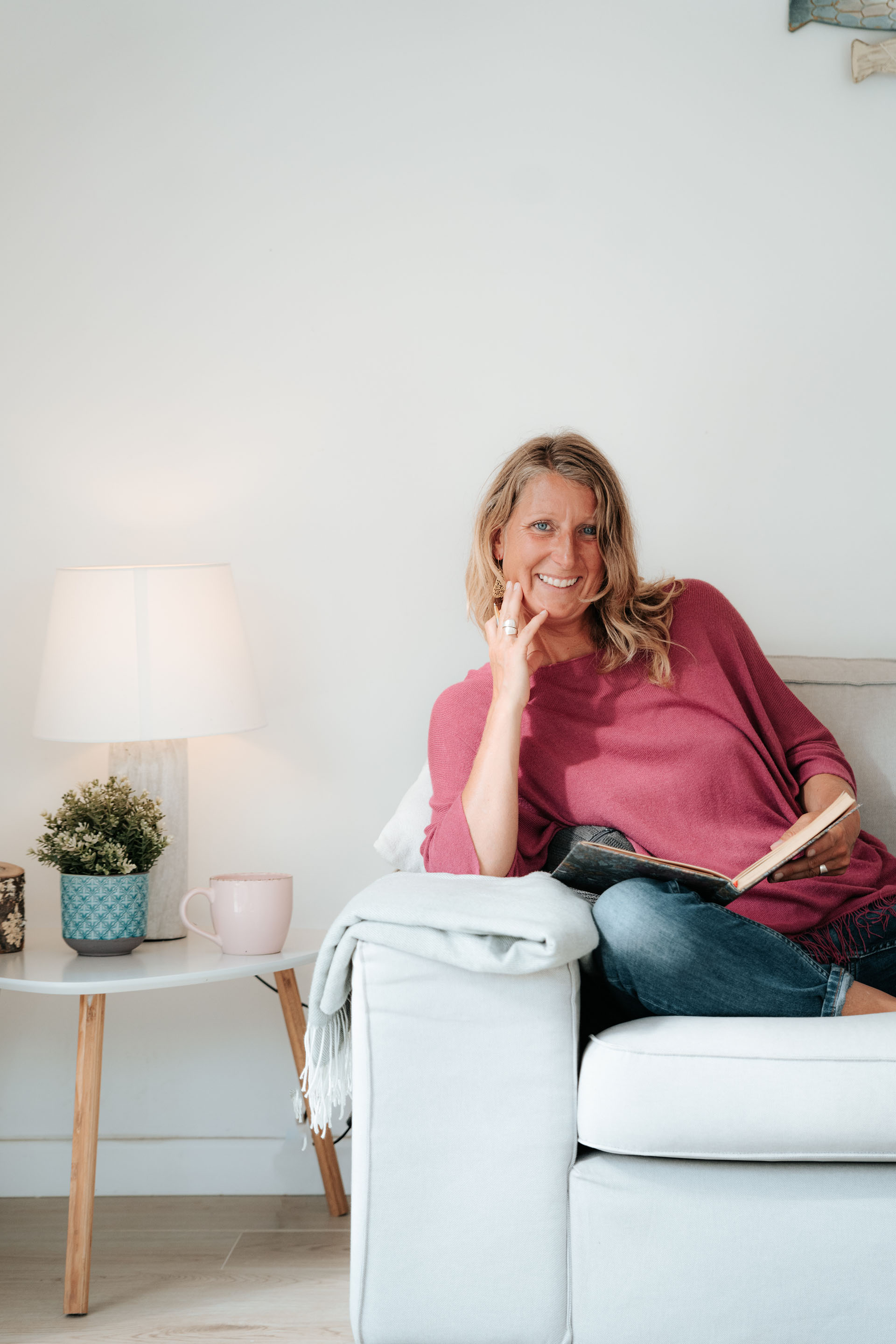 martina knall burnout coach sitzt entspannt auf sofa und laechelt