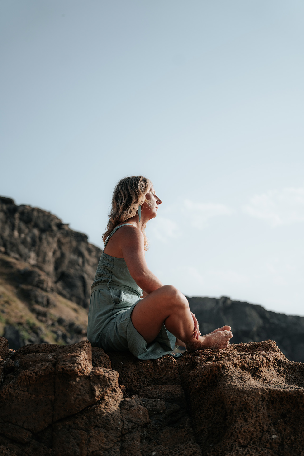 Martina Knall sitzt ruhig in der Natur auf einem Felsen – Erdung, Körperwahrnehmung und nachhaltige Regeneration des Nervensystems.