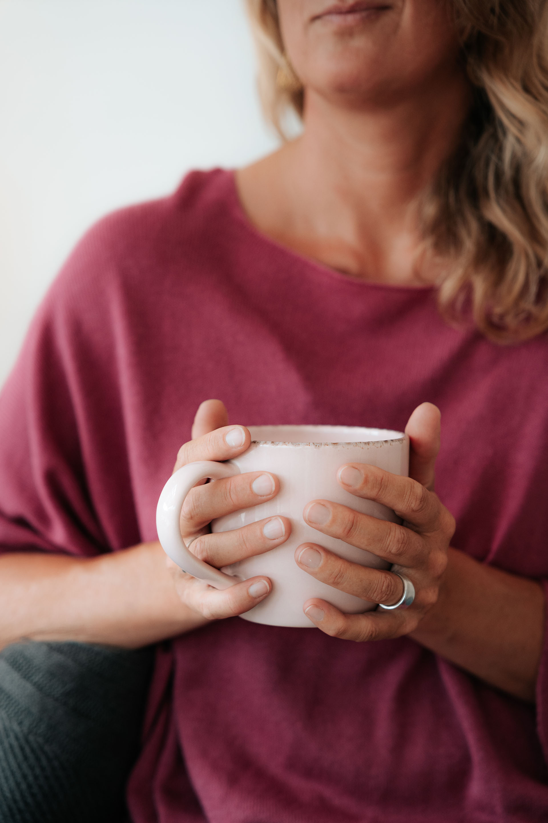 Nahaufnahme von Händen, die eine warme Tasse halten – achtsame Pause und Selbstfürsorge bei Erschöpfung und Burnout.