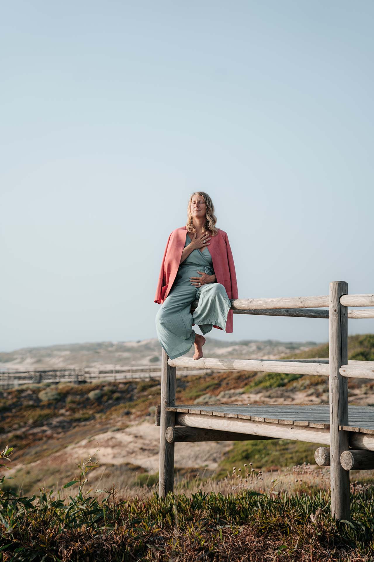 Martina Knall steht in der Natur mit der Hand auf dem Herzen – Verbindung zum Körper, Nervensystem-Regulation und innere Stabilität.