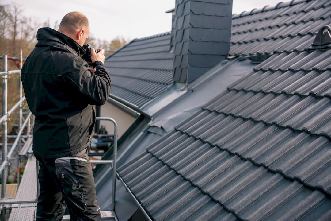 Dachdecker fotografiert Details des Dachs zur Wartung