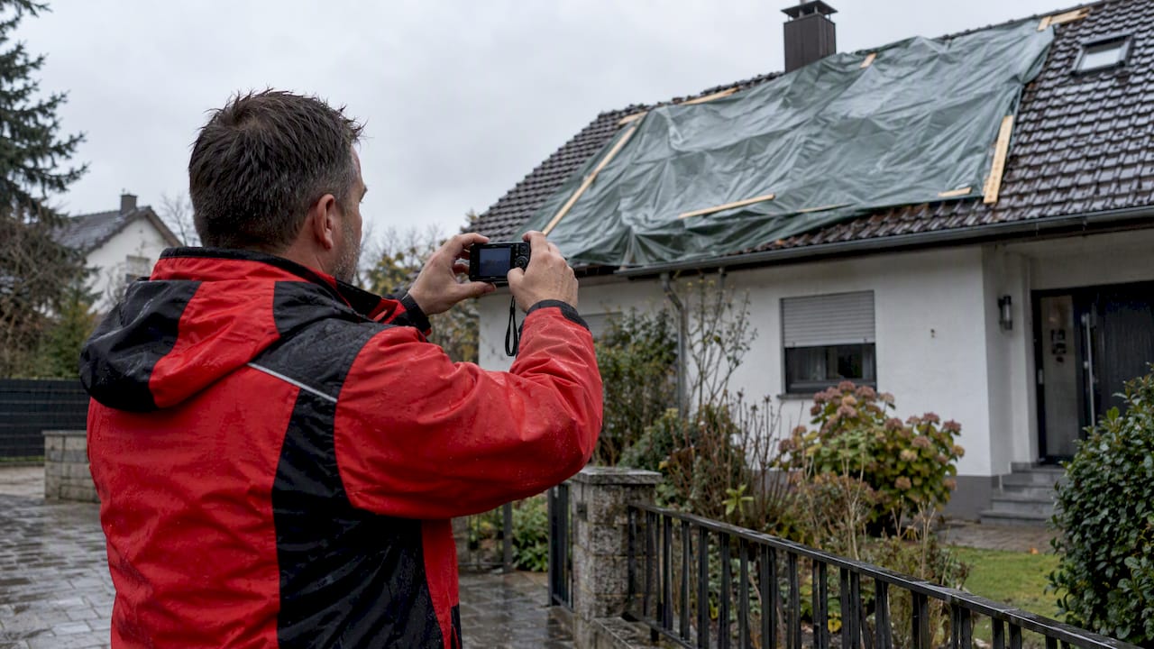 Dachdecker macht Foto von befestigter Schutzplane